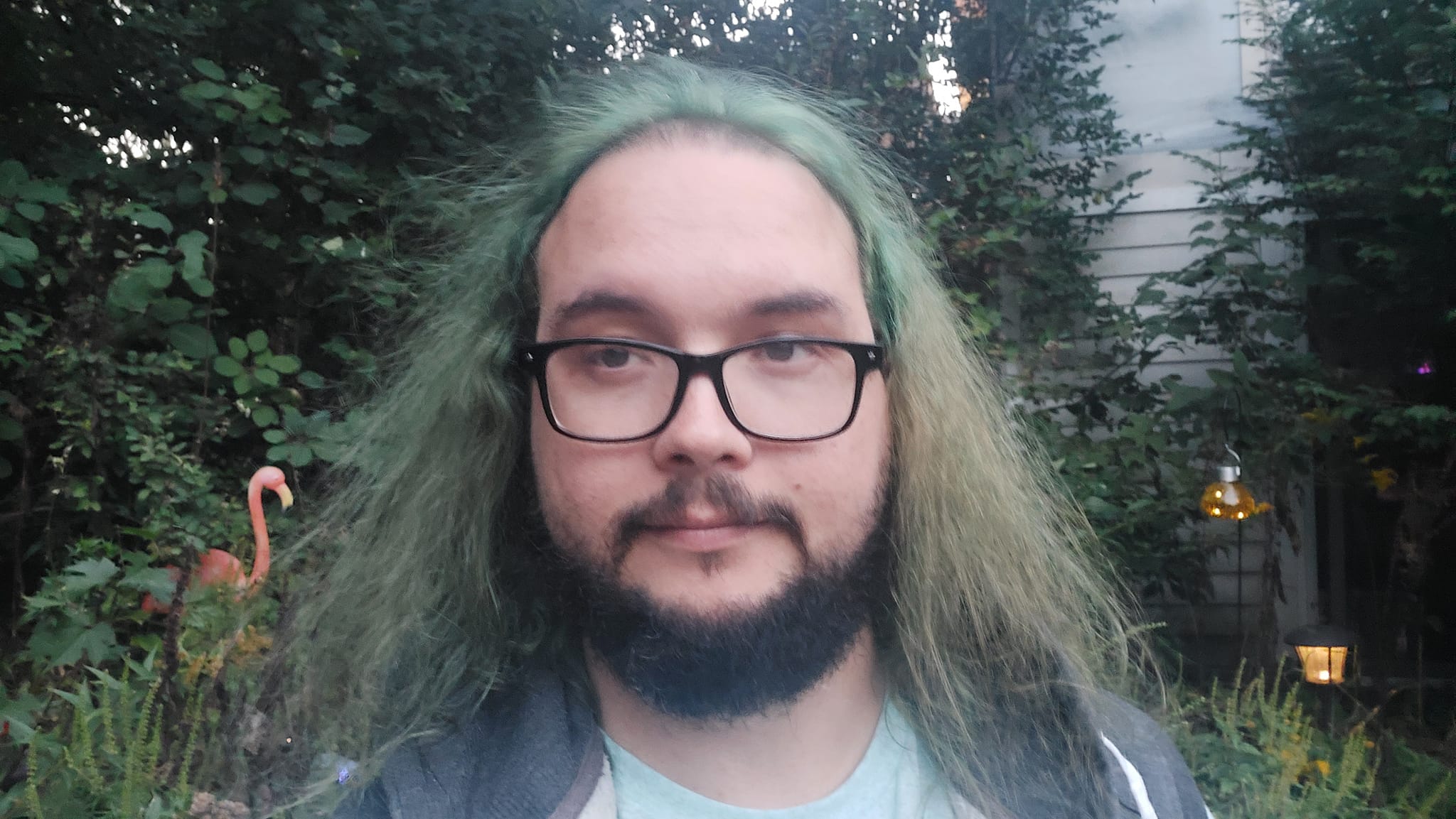 A man with green hair and a beard is outside after dark, Photo 2